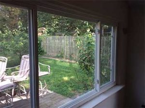 Large three lite slider window with view into backyard