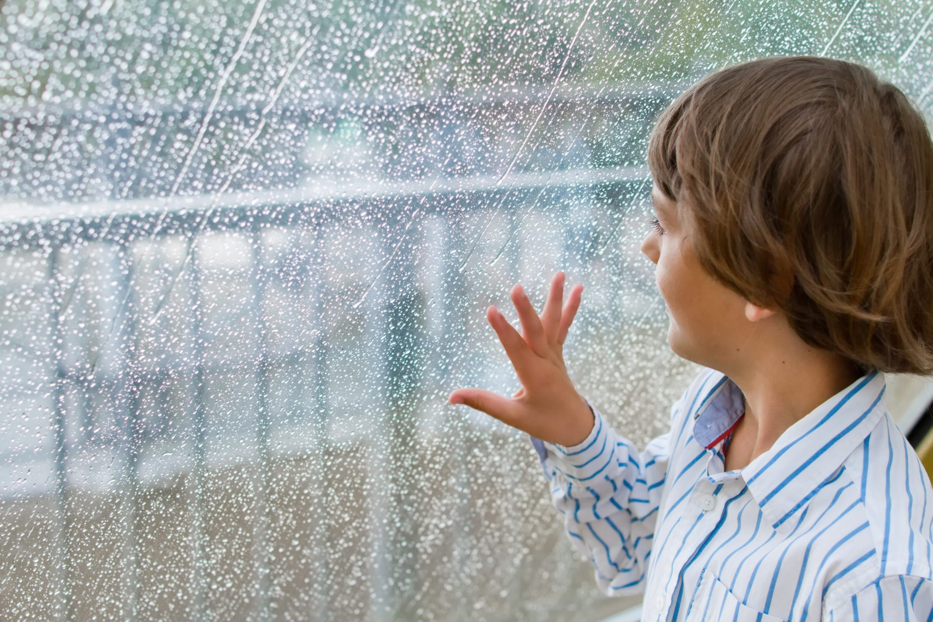 boy looking outside stormy window