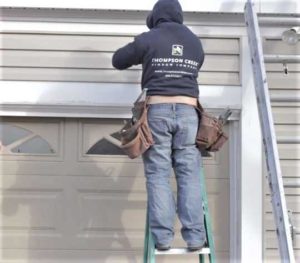 Thompson Creek worker installing vinyl siding on home