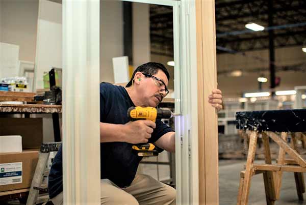 Man working with drill on Thompson Creek window