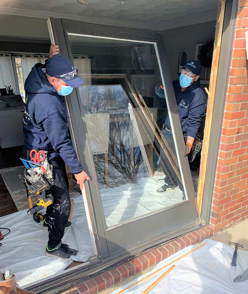 Thompson creek replacement sliding door being installed by two workers