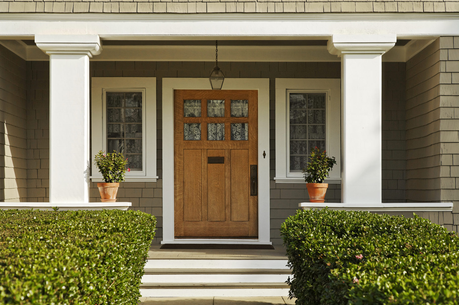 A,Concrete,Walkway,Bordered,With,Hedged,Shrubs,Leads,To,The