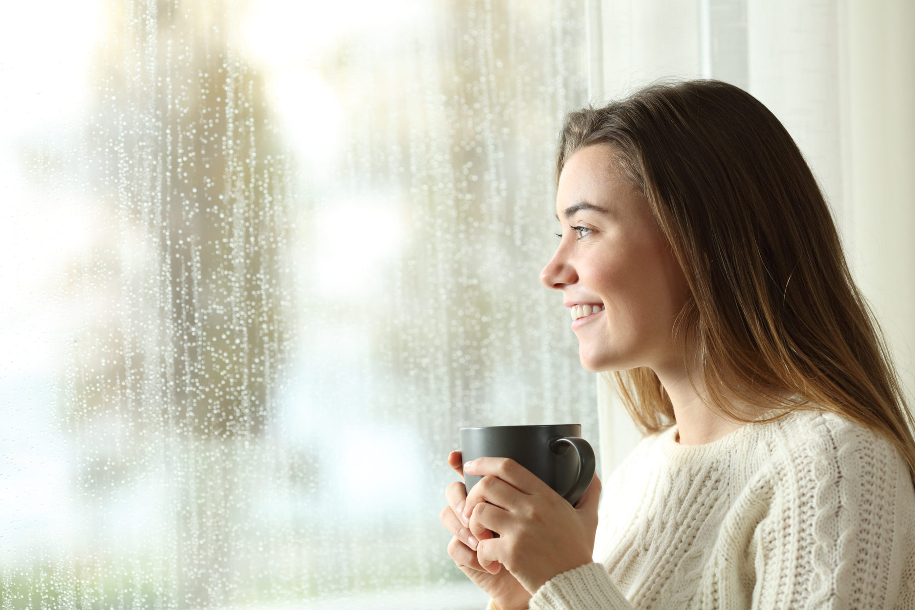 Happy,Teen,Holding,A,Mug,Looking,Through,A,Window,At